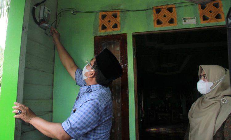 Bupati Bersama Ketua TP PKK Saat Menyalakan Listrik di Rumah Warga . (Foto : Hery dan Putra)